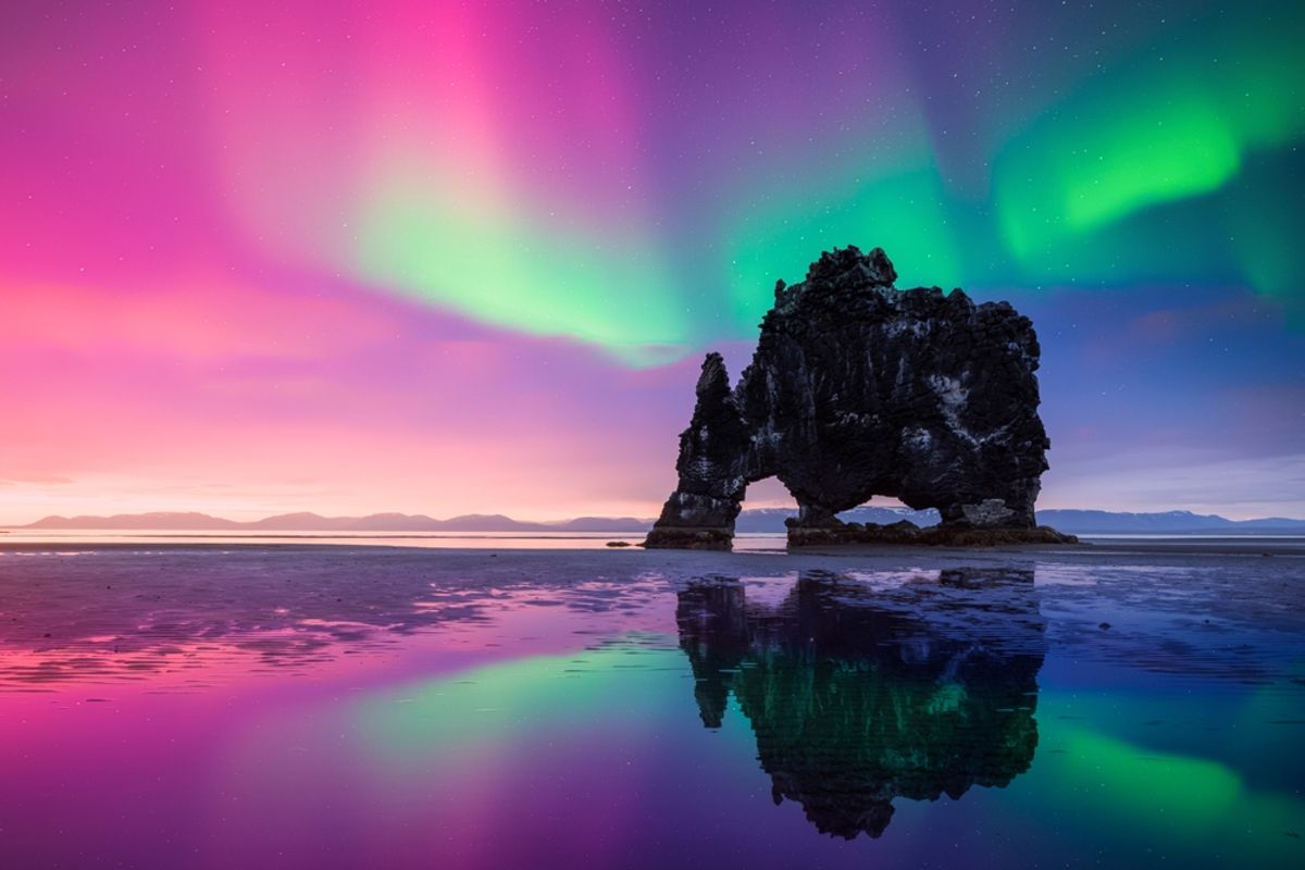 Purple and green Northern lights over Basalt stack Hvitserkur on the Vatnsnes peninsula, Iceland