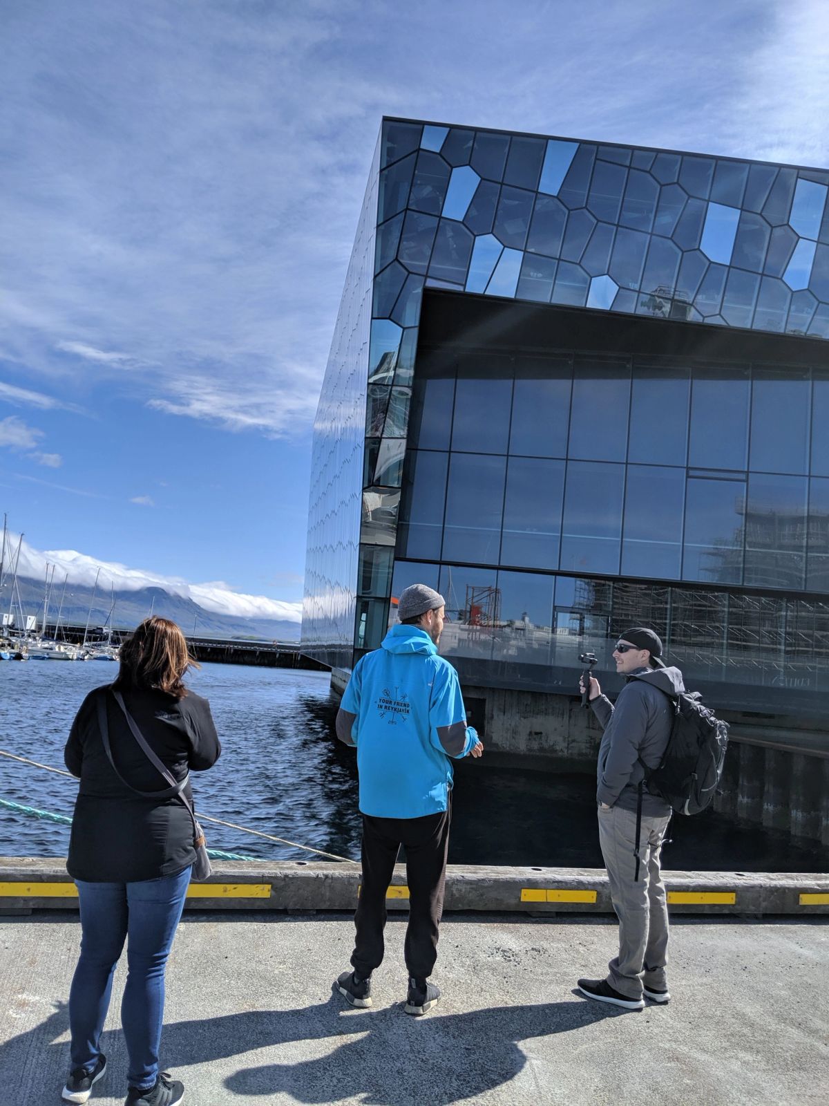 Tourists outside Harpa concert hall by the Reykjavík harbour