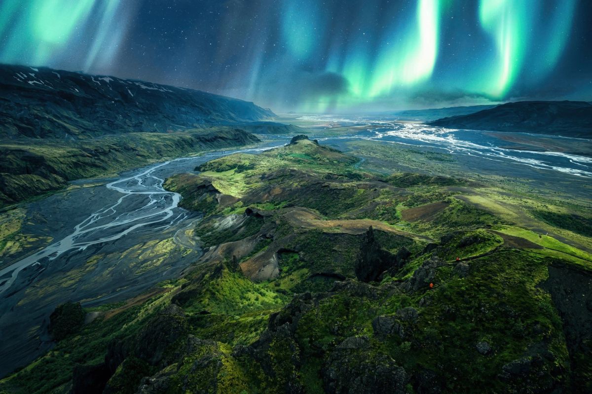 Green aurora over a river valley seen from the air