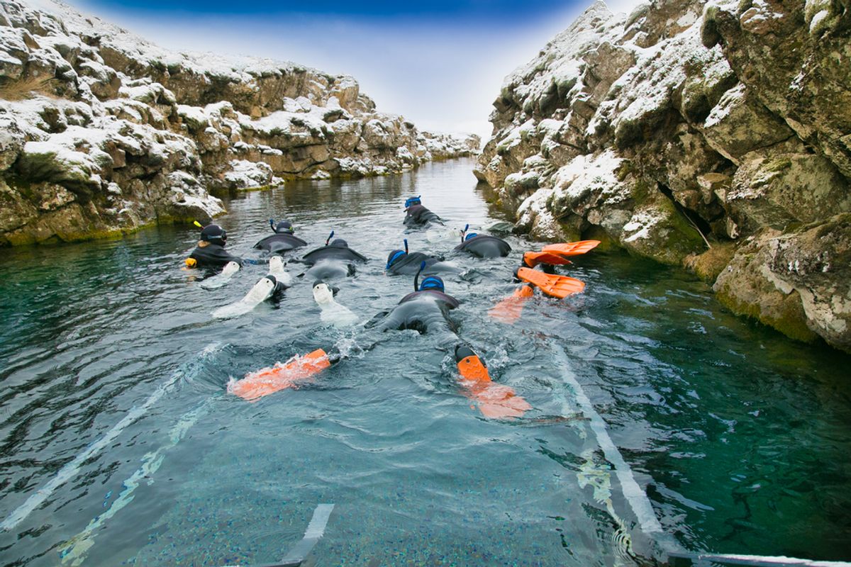 Scuba divers preparing to enter the water at the Silfra rift in Thingvellir National Park