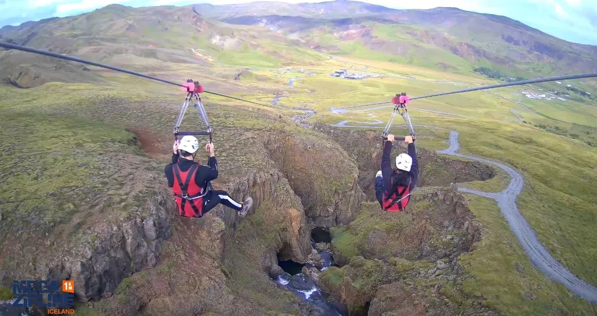 Zipline rider soaring over the cliffs of Svartagljúfur gorge in South Iceland