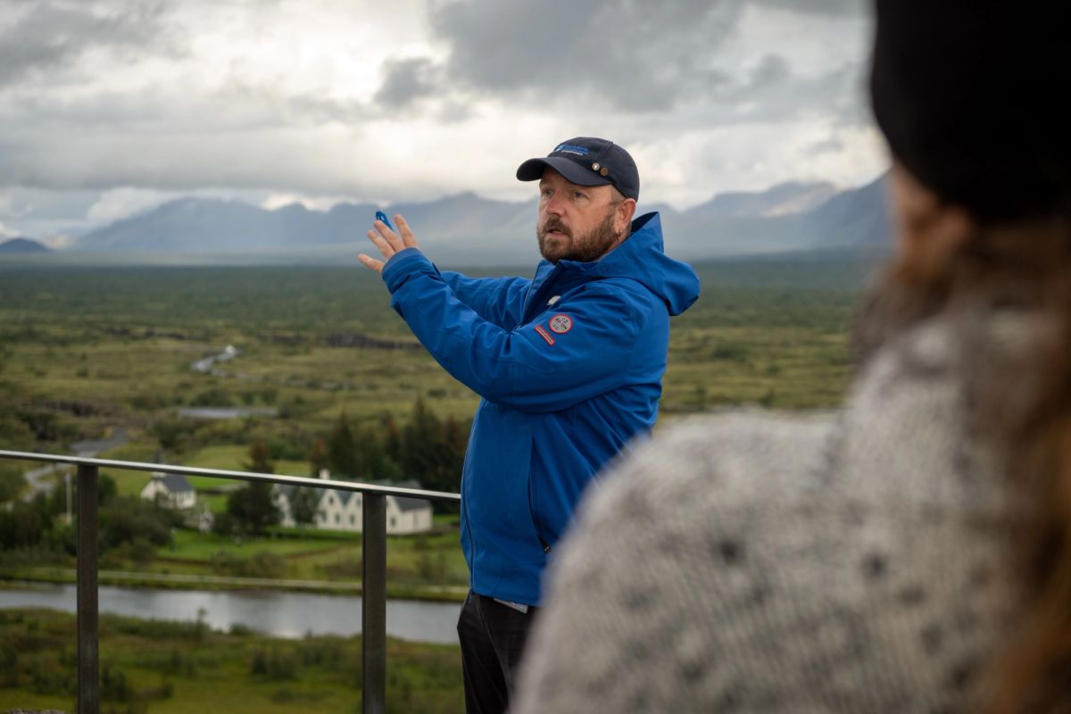 A guide explaining the landscape to visitors at an overlook in Thingvellir National Park