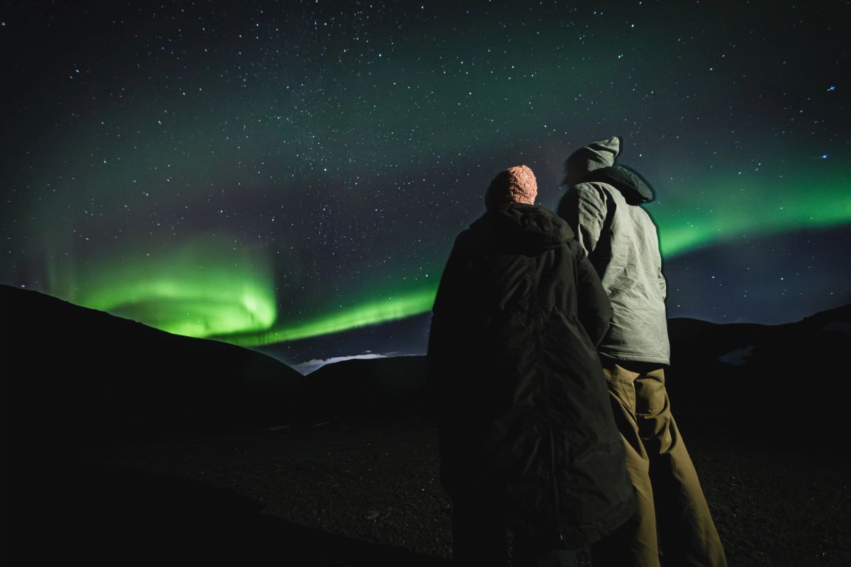 A couple watching the northern lights on a clear night