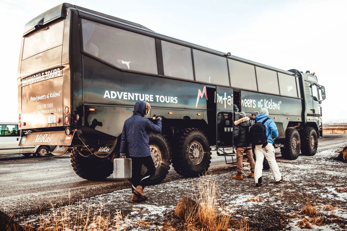 A monster truck adventure vehicle with passengers boarding