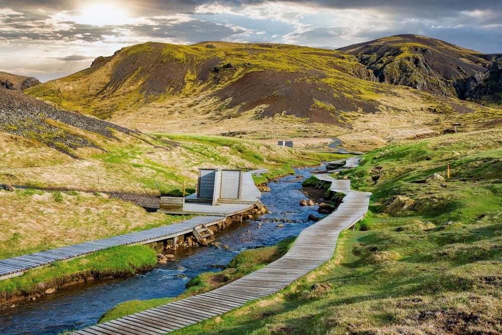 Wooden boardwalk and changing rooms by hot river stream