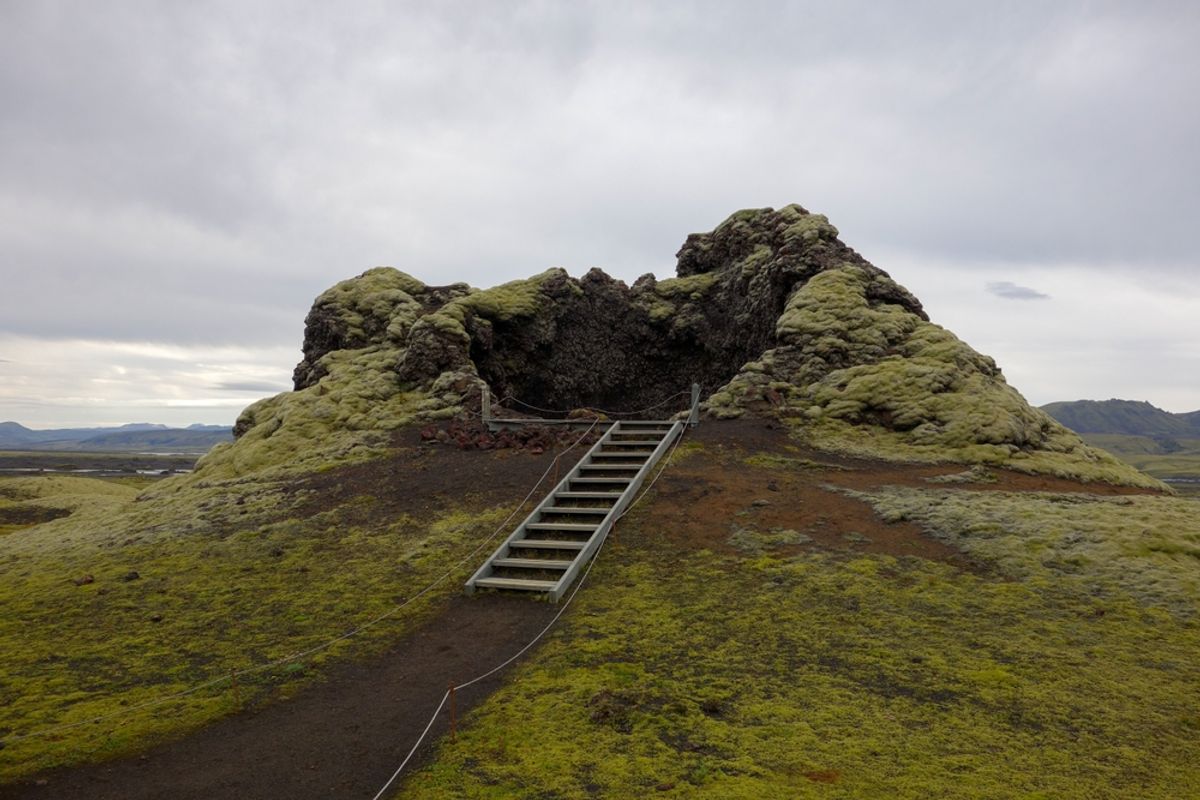 Wooden stairs winding up a moss-covered volcanic crater in Iceland
