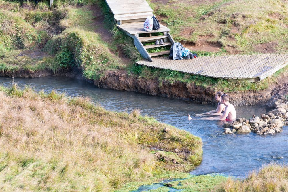 Bathers sitting in the warm river at Reykjadalur