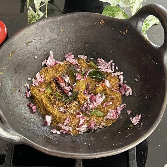Chukka kura Pachadi served in a black mud pan.