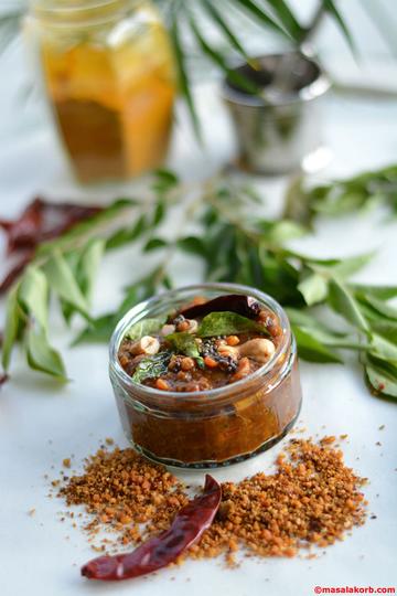 Jar of tamarind paste with peanuts and dry chillies, spice powder in front
