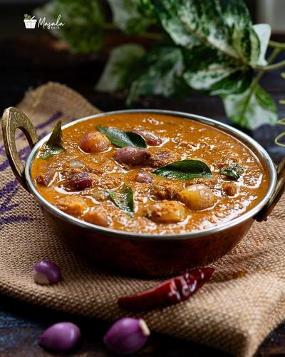 Small onion curry served in a copper kadai.