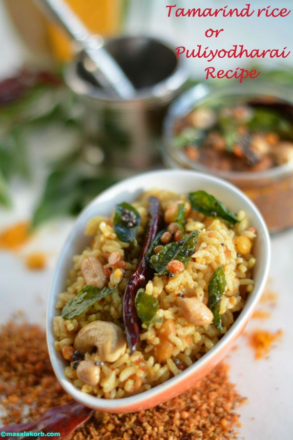 Tamarind rice with peanuts, cashews, a dry red chilli and curry leaves in a white bowl