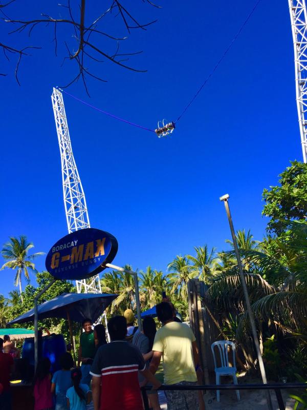 Swing ride cable stretched between two tall towers under a deep blue sky