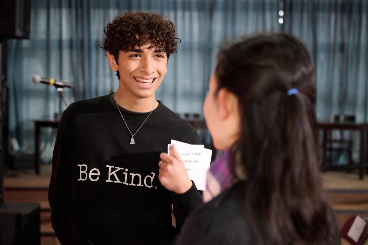 Joseph Arujo smiling in a Be Kind sweatshirt during a Born This Way Foundation interview
