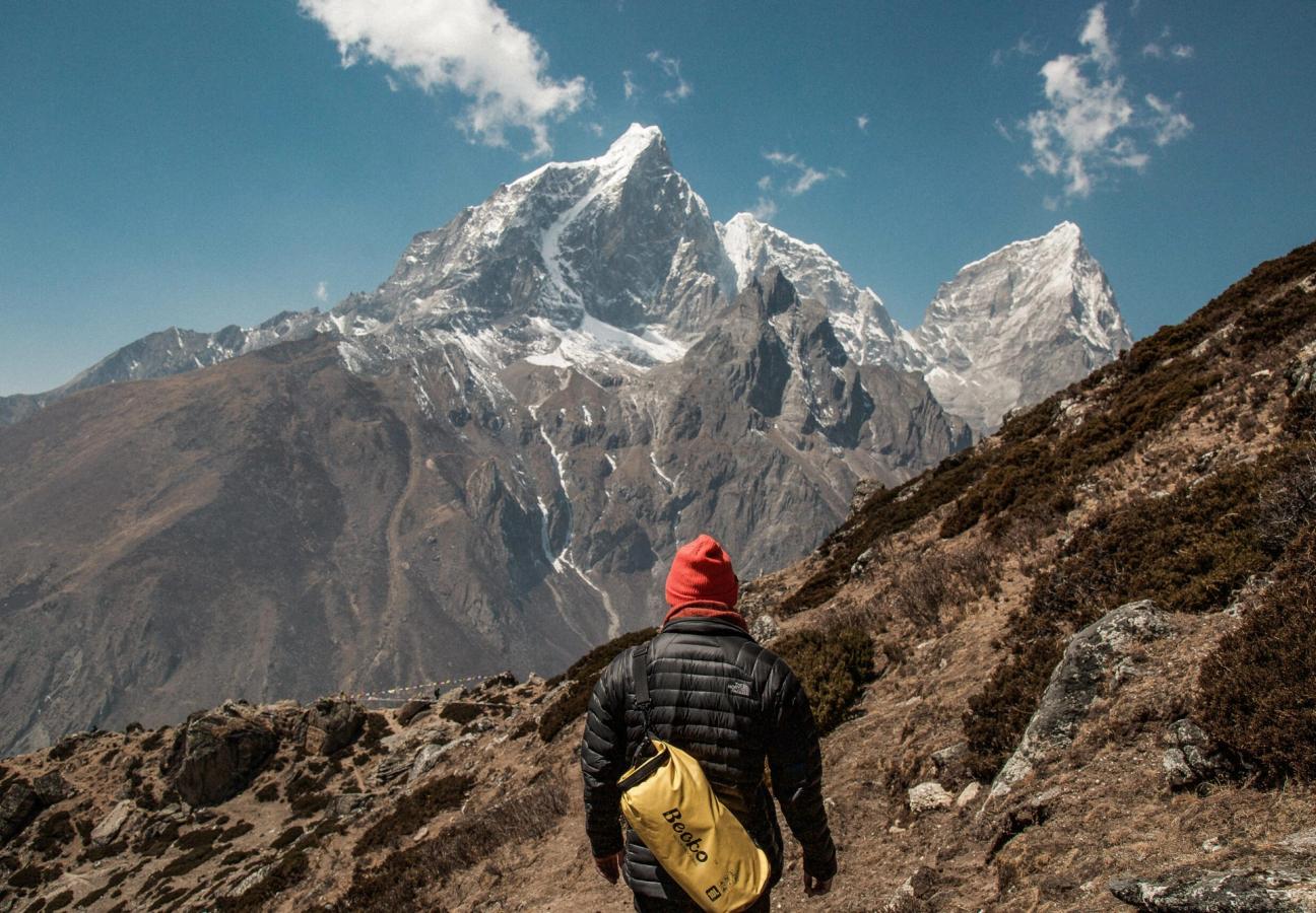 man stares out over mountain wearing hat