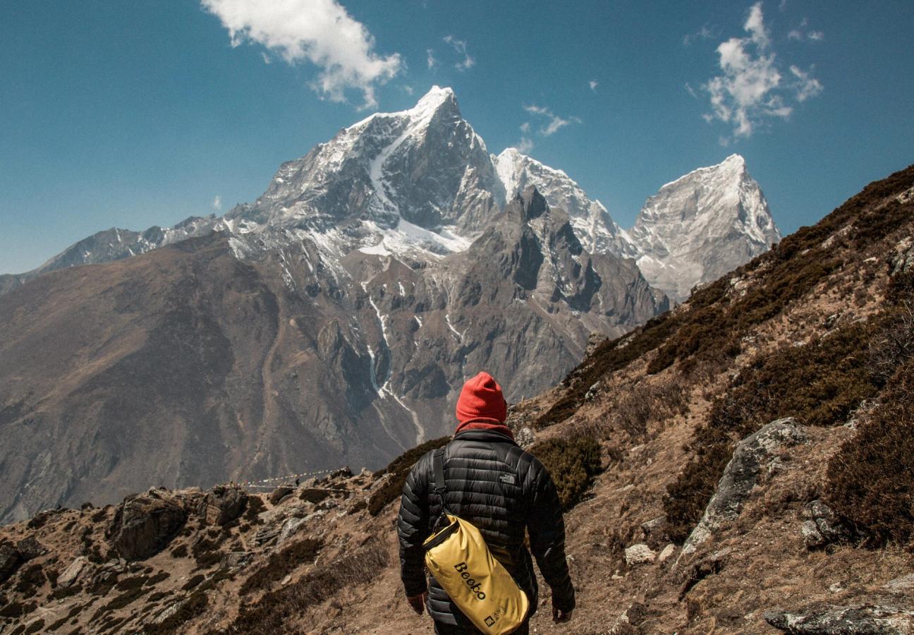 man stares out over mountain wearing hat
