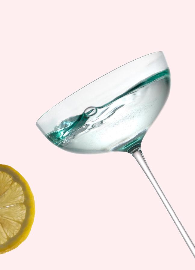 A full martini glass and a slice of lemon