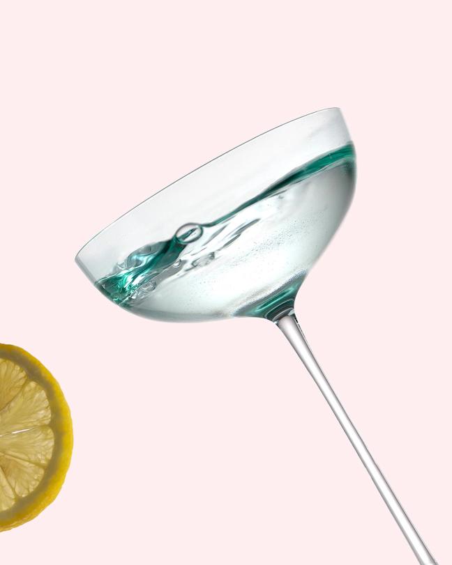 A full martini glass and a slice of lemon