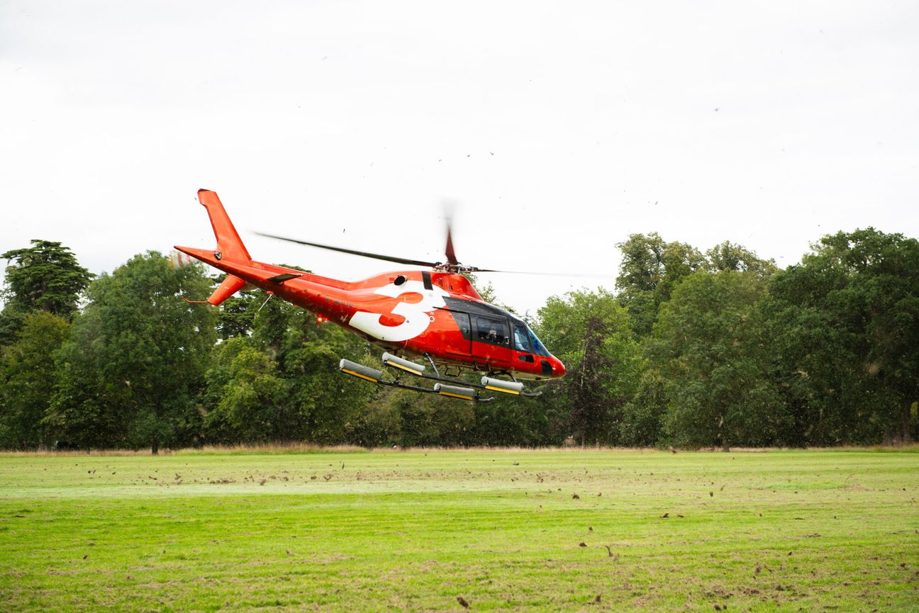 Red Helicopter coming in to land on grass