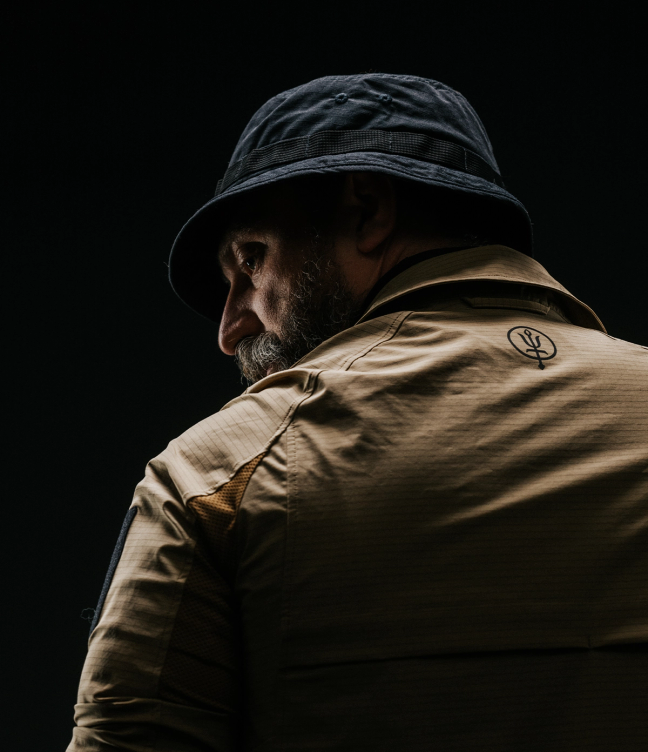 Overshoulder shot of man wearing carbon shirt and watchman boonie hat