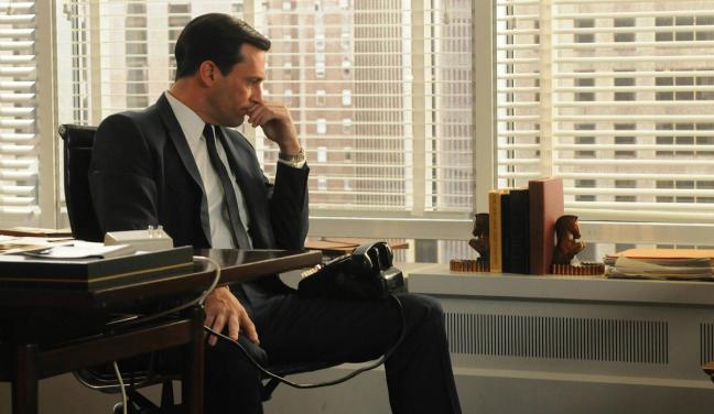 Don Draper with telephone thinking in office in Mad Men