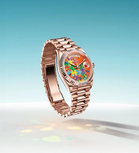 Rolex watch with jigsaw puzzle Dial, Turquoise blue, red, fuchsia, orange, green and yellow pieces fit together on a single-colour background.