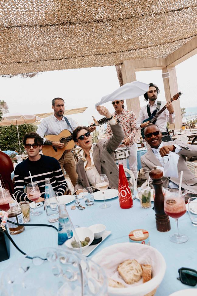 Guests sat at a table enjoying the party with musicians play behind them