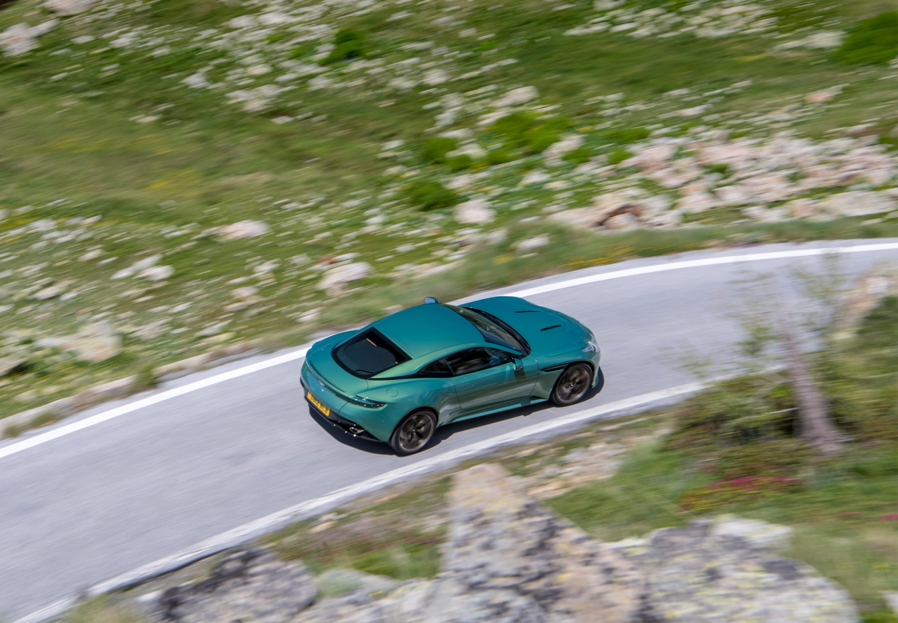 Green Aston Martin DB12 driving on the road