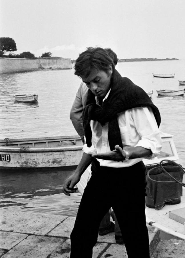 Style icon Alain Delon wearing a jumper over his shoulders
