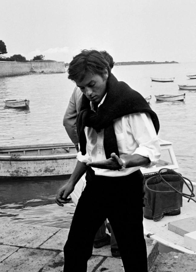 Style icon Alain Delon wearing a jumper over his shoulders