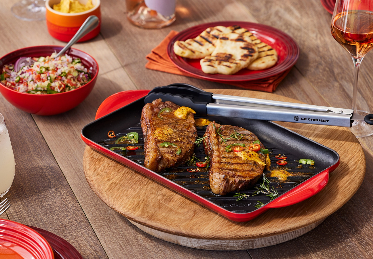 Le Creuset Cerise Red Grill Set in use on table for a meal