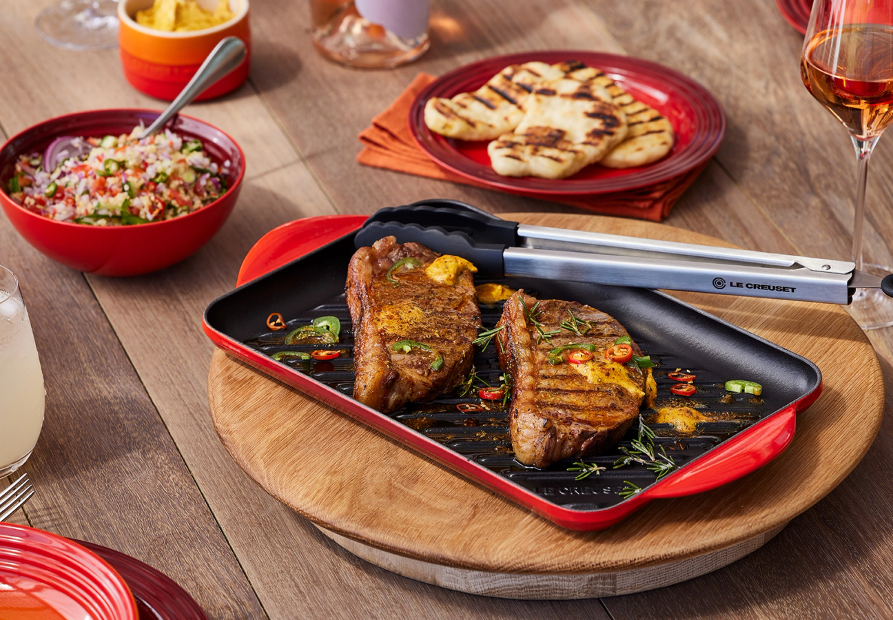 Le Creuset Cerise Red Grill Set in use on table for a meal