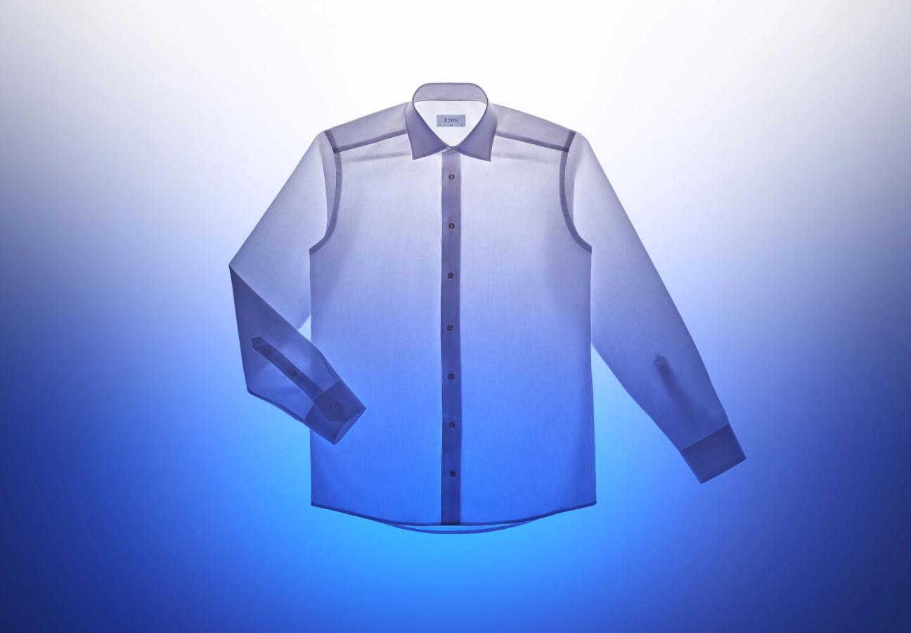 white Eton shirt backlit exposing all seams on a white and blue background
