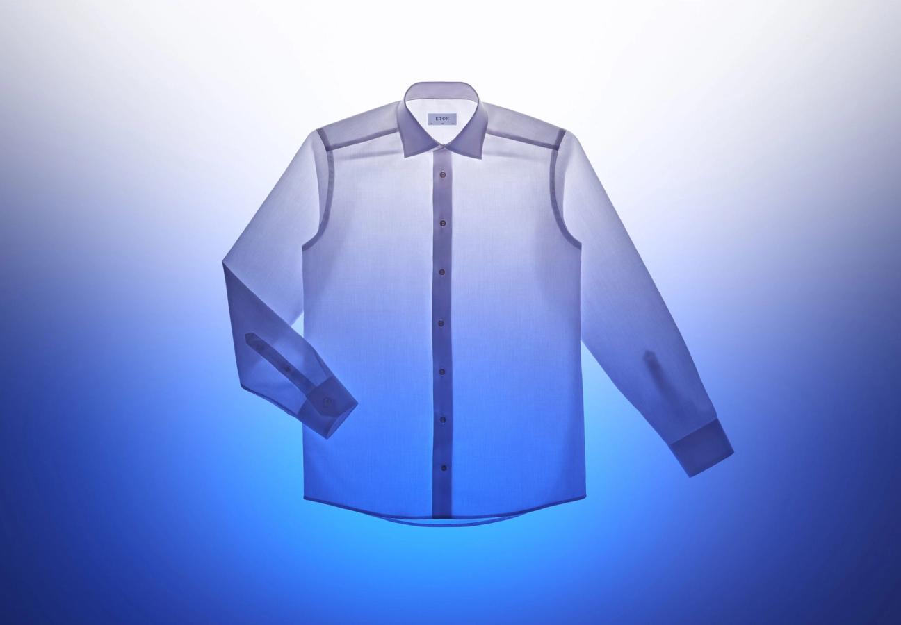 white Eton shirt backlit exposing all seams on a white and blue background
