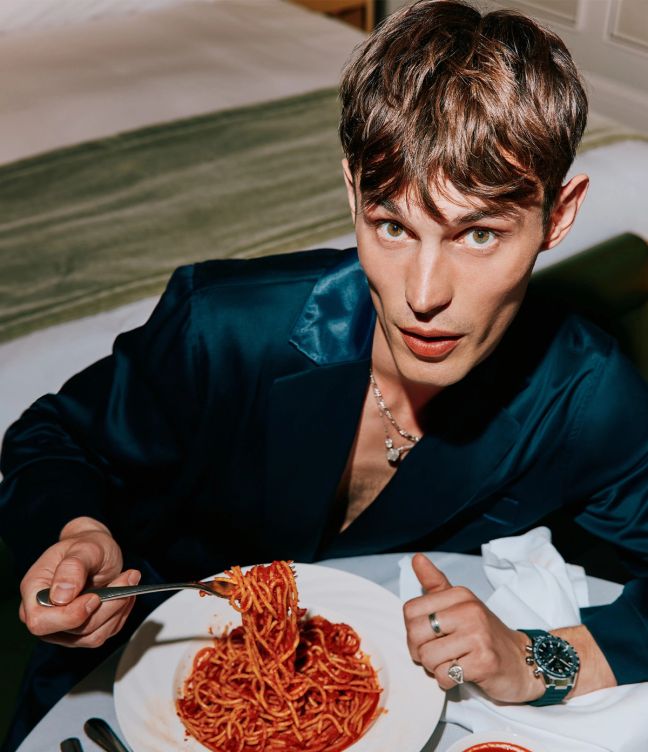 Model Kit Butler in a navy dressing gown about to eat a plate of spaghetti
