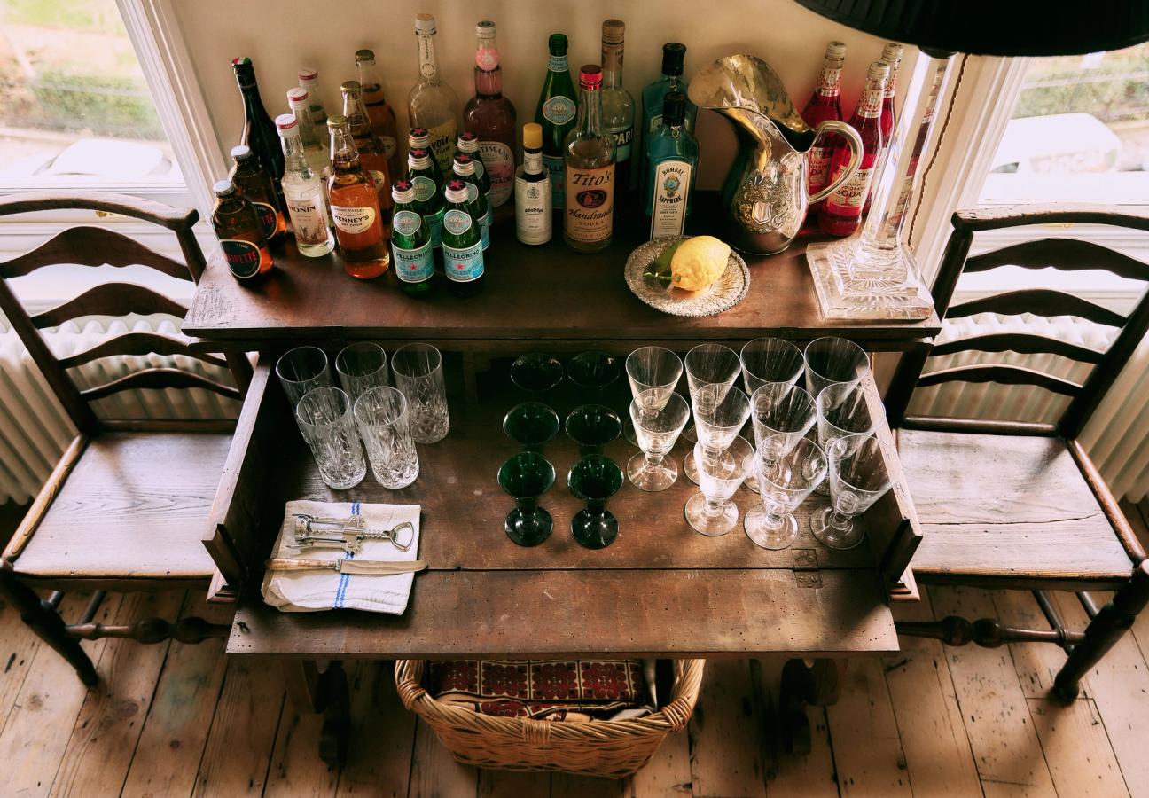 Drinks table with bottles and antique glassware in Jamie Sharp’s home