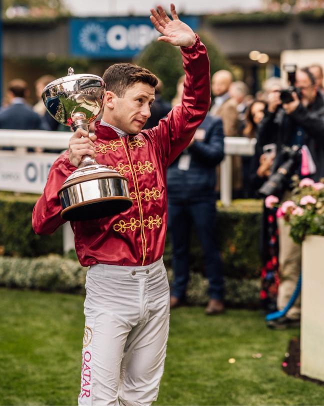 Jockey holding a trophy and waving at Ascot