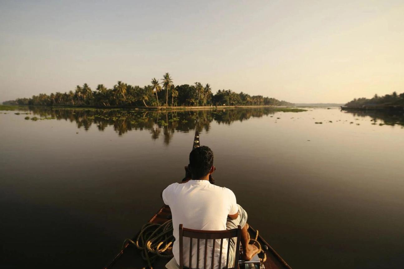  Man looking out on the river from a house boat in Kerala