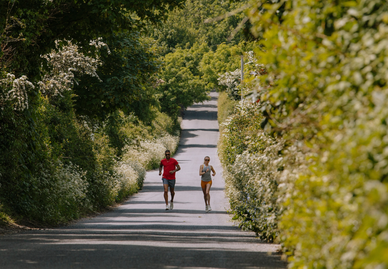 Two people running down a lane, for a Tracksmith campaign