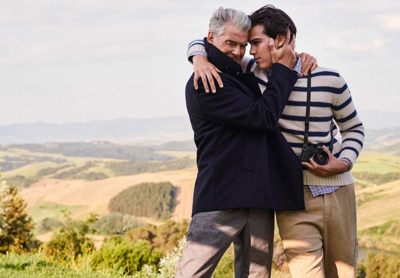 Pierce Brosnan embracing his son Paris Brosnan clutching a camera wearing Paul&Shark’s jumpers and jackets
