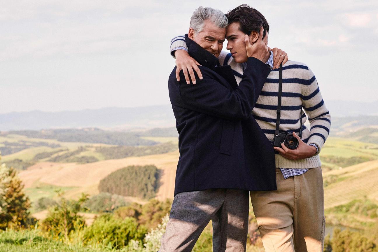 Pierce Brosnan embracing his son Paris Brosnan clutching a camera wearing Paul&Shark’s jumpers and jackets