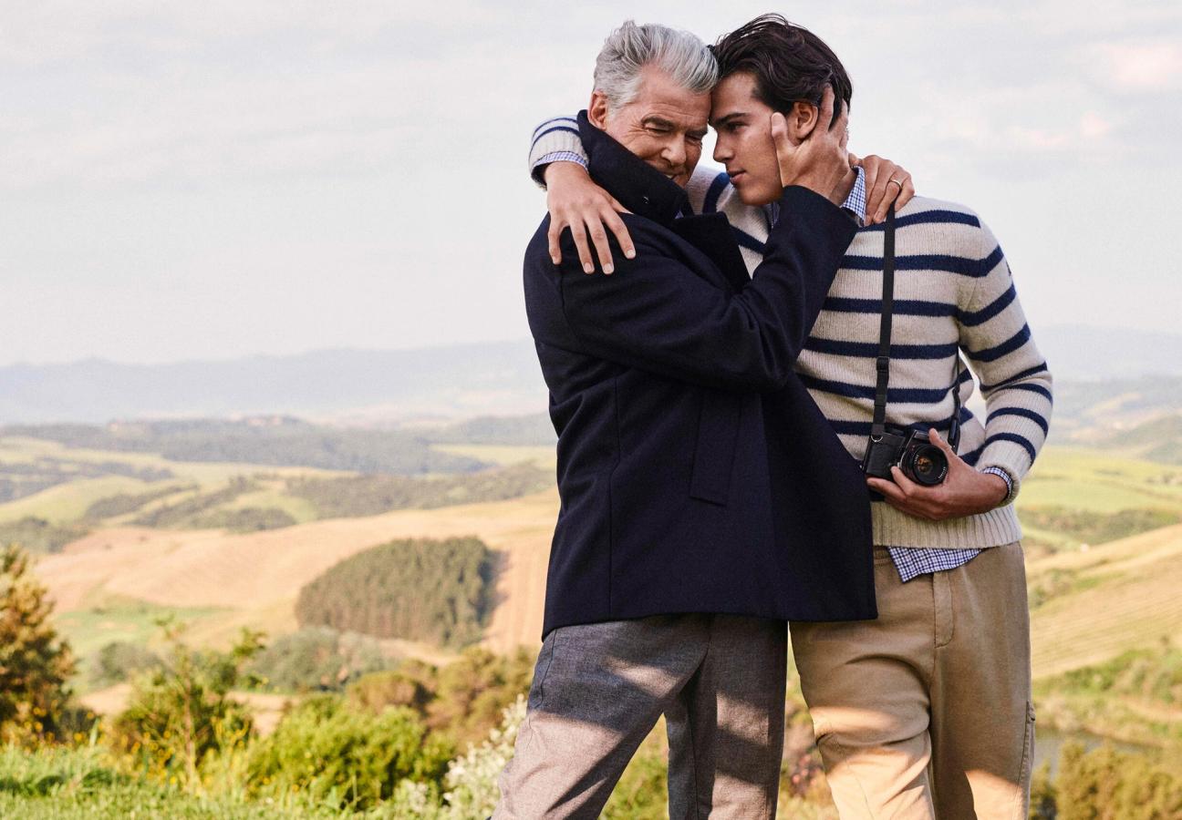 Pierce Brosnan embracing his son Paris Brosnan clutching a camera wearing Paul&Shark’s jumpers and jackets