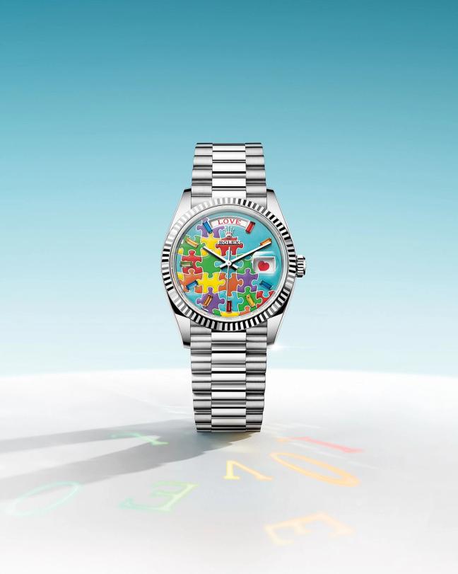 Rolex watch with jigsaw puzzle Dial, Turquoise blue, red, fuchsia, orange, green and yellow pieces fit together on a single-colour background.