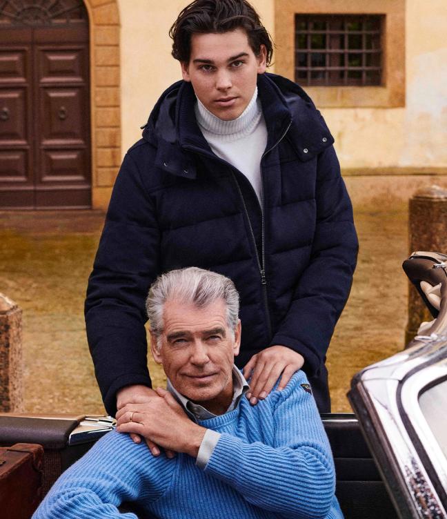 Pierce Brosnan sat in a convertible car with his son Paris Brosnan leaning against the car hand of Pierce's shoulders wearing Paul&Shark’s jackets and jumpers