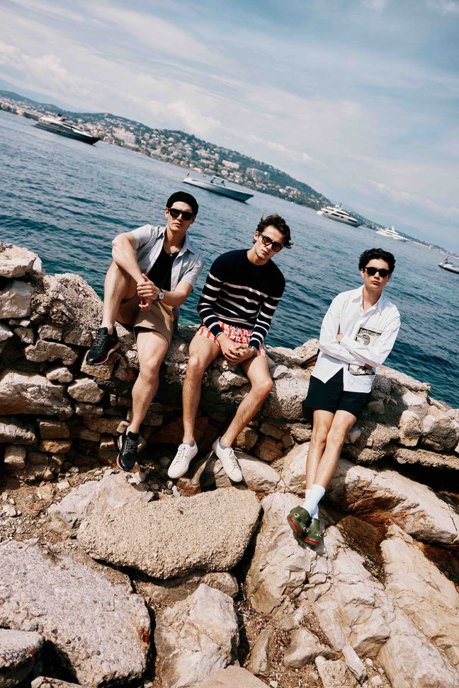 Sam Way, William Franklin Miller and William Gao sat on rocks along the Cannes sea front