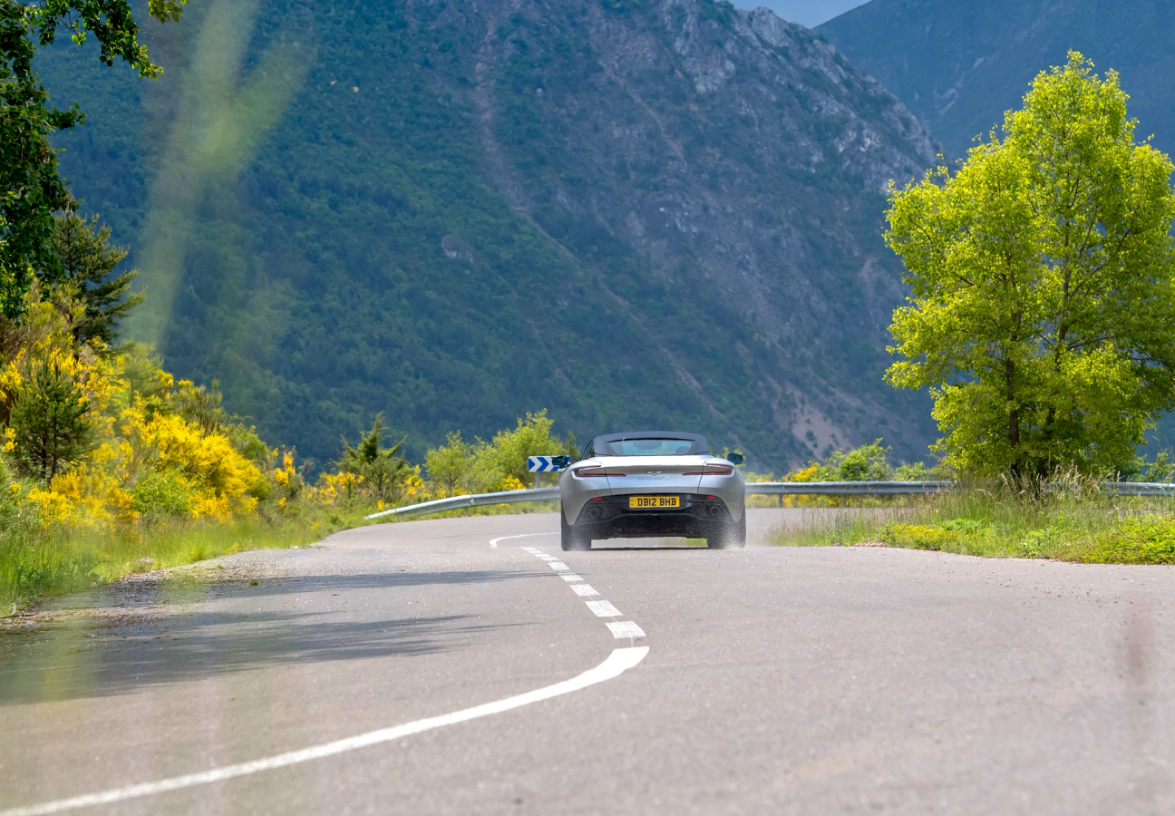 Silver Aston Martin DB12 driving on the road