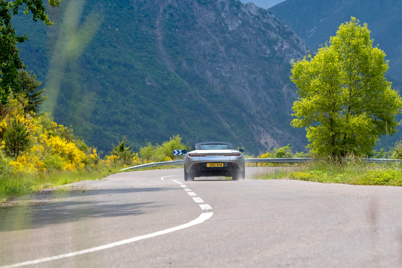 Silver Aston Martin DB12 driving on the road