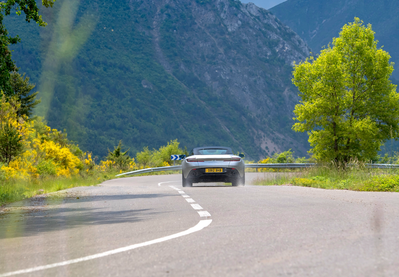 Silver Aston Martin DB12 driving on the road