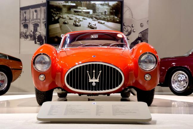 The front of a red Maserati A6GCS-53 in a showroom