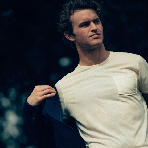 Matthew Woodruff, pulling on a blazer over Tracksmith clothing