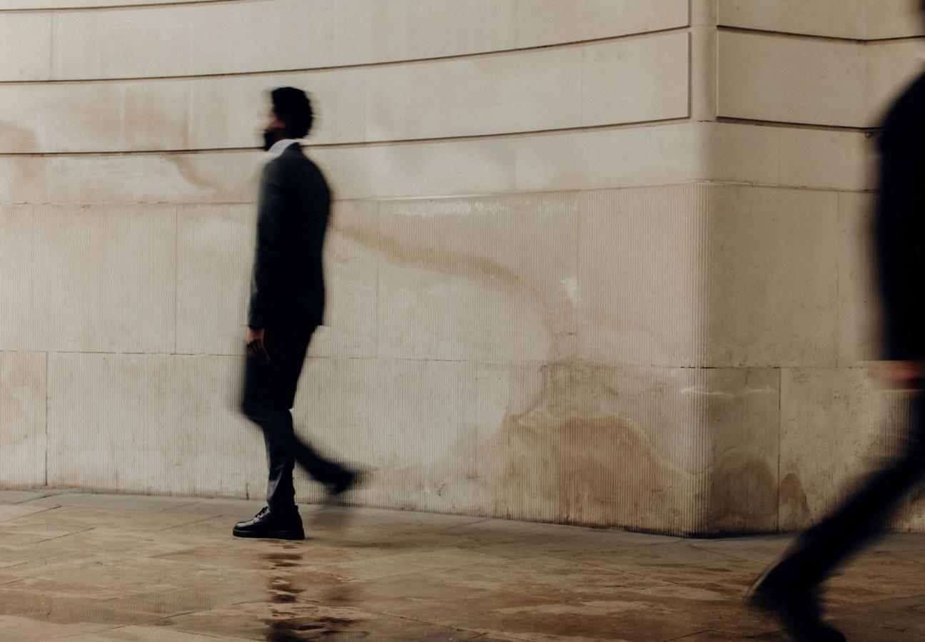 man walking past building with motion blur